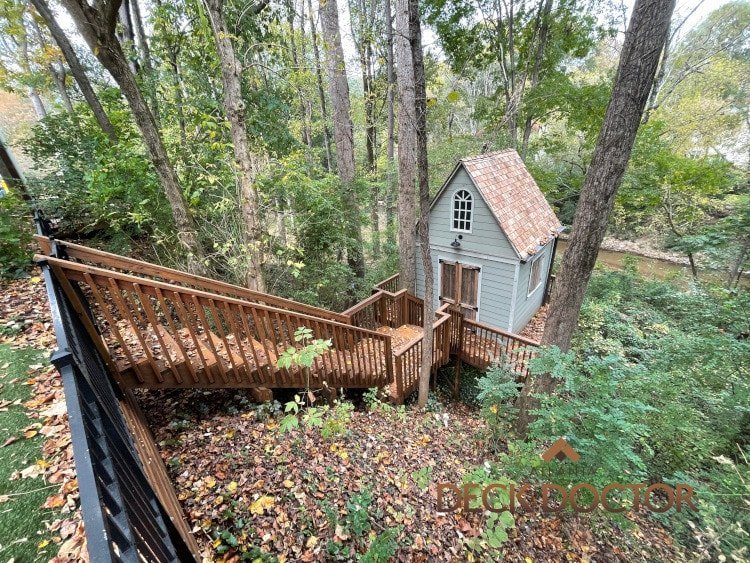 PlayHouse Deck Staining & Sealing Wooden Steps Leading Down To Playhouse In Wooded Lot With Creek In Background. Playhouse Deck Was Stained And Sealed With TWP Cedar.